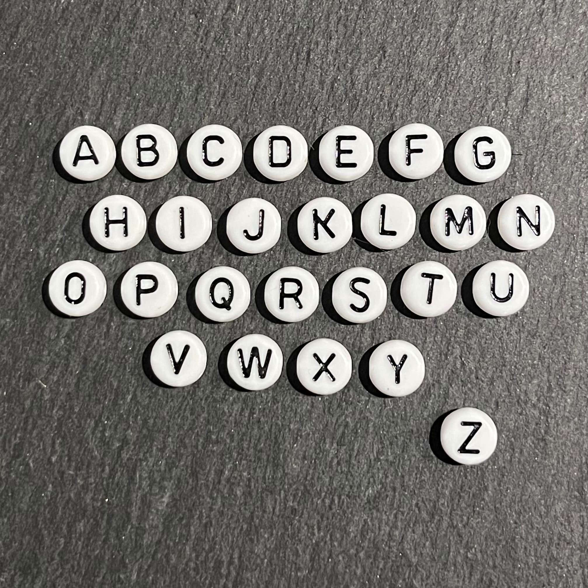 Novalee créatrice de bijoux situé sur Aix en Provence, bijoux fabriqué main. Perles alphabet fond blanc et lettre noire