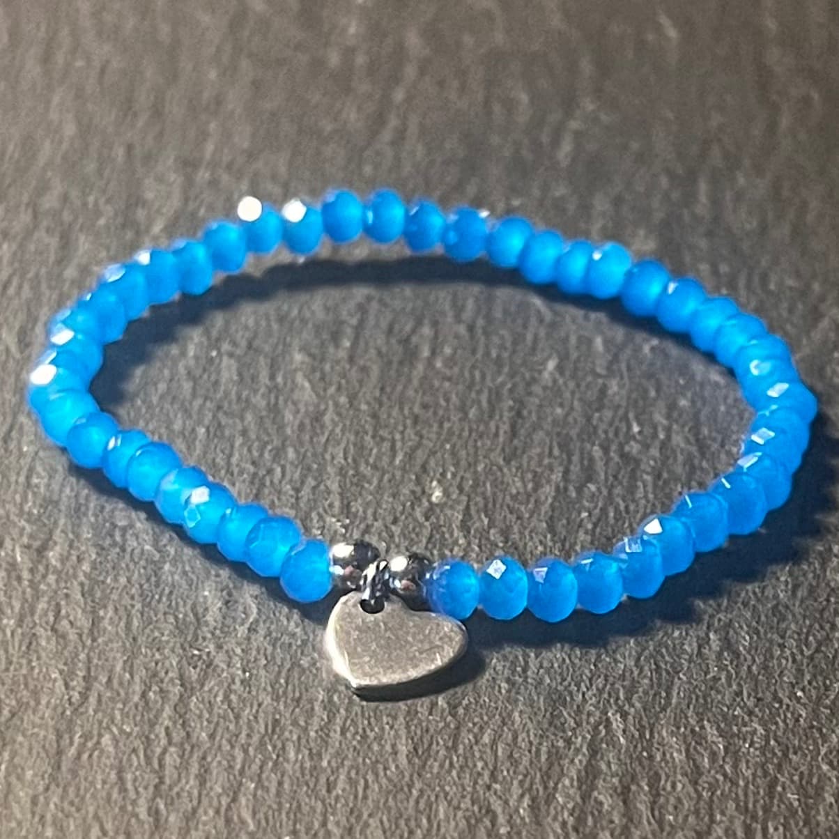 Bracelet enfant en perles à facettes aux couleurs acidulées et d'un pendentif cœur en acier inoxydable argenté ou doré conçu sur mesure avec des perles