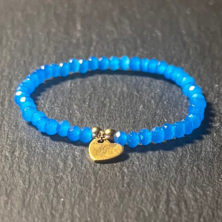 Bracelet enfant en perles à facettes aux couleurs acidulées et d'un pendentif cœur en acier inoxydable argenté ou doré conçu sur mesure avec des perles