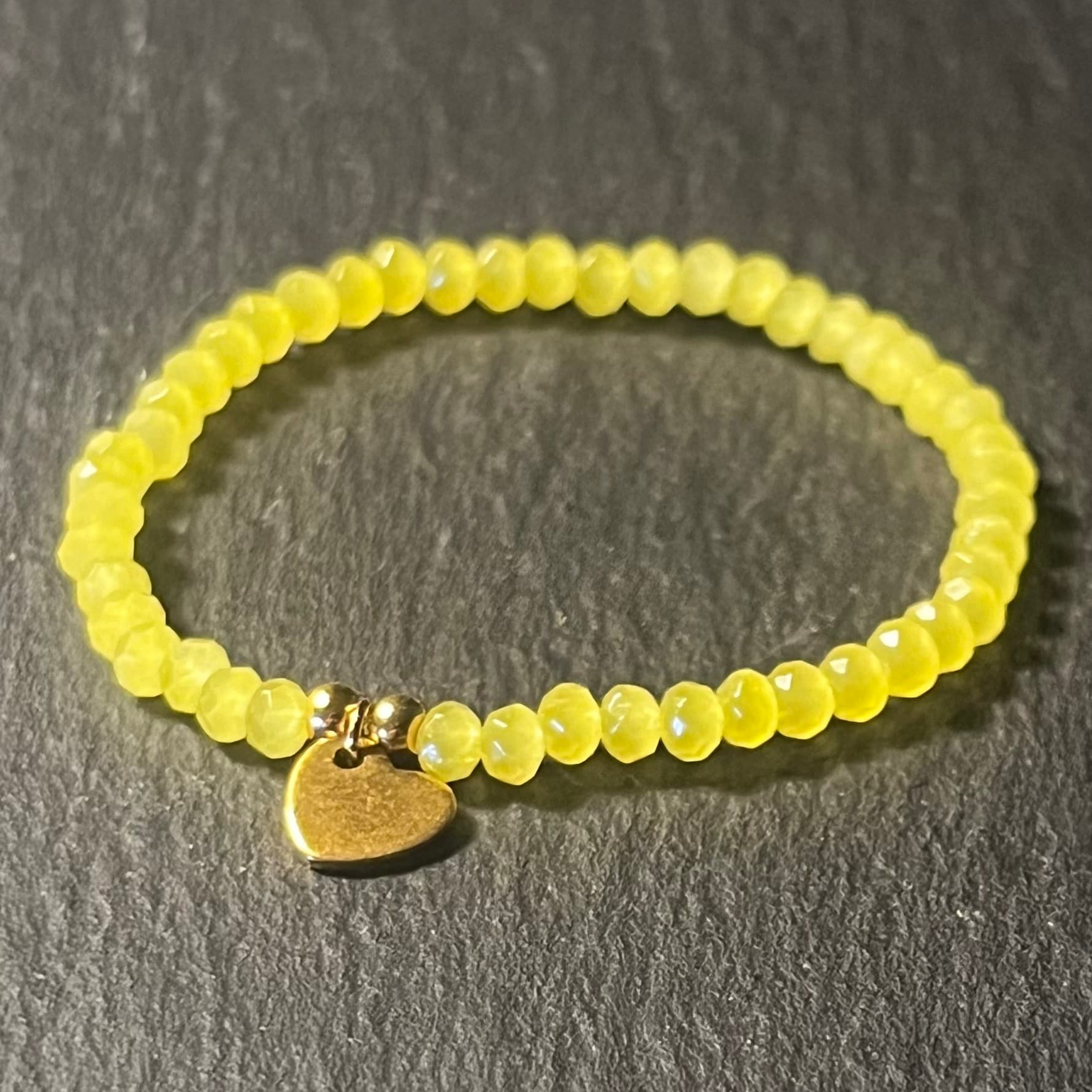 Bracelet enfant en perles à facettes aux couleurs acidulées et d'un pendentif cœur en acier inoxydable argenté ou doré conçu sur mesure avec des perles