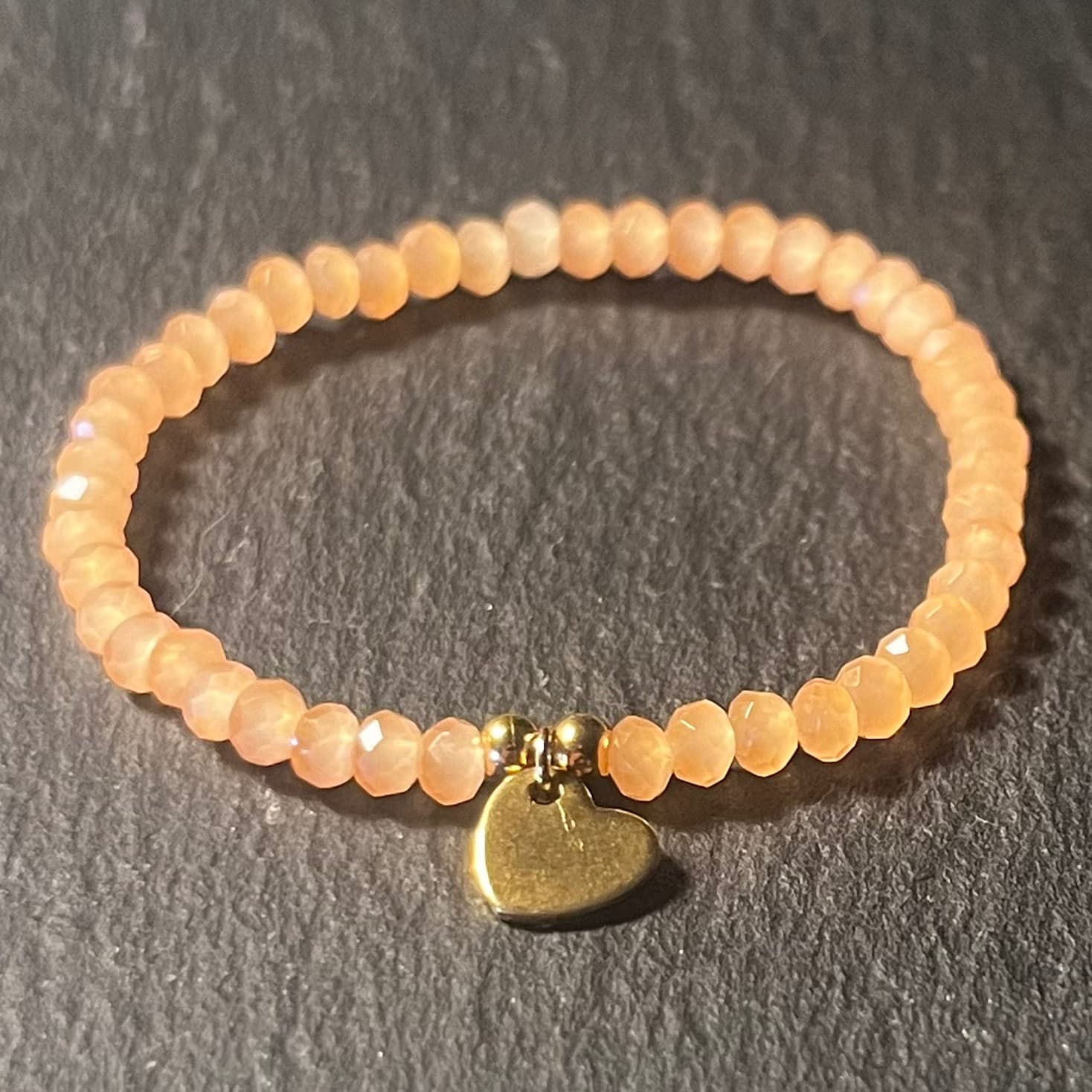 Bracelet enfant en perles à facettes aux couleurs acidulées et d'un pendentif cœur en acier inoxydable argenté ou doré conçu sur mesure avec des perles