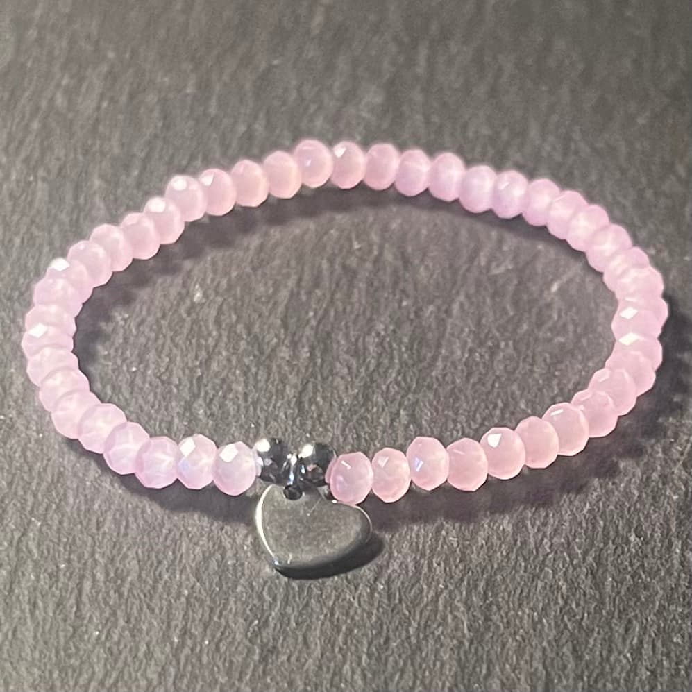 Bracelet enfant en perles à facettes aux couleurs acidulées et d'un pendentif cœur en acier inoxydable argenté ou doré conçu sur mesure avec des perles