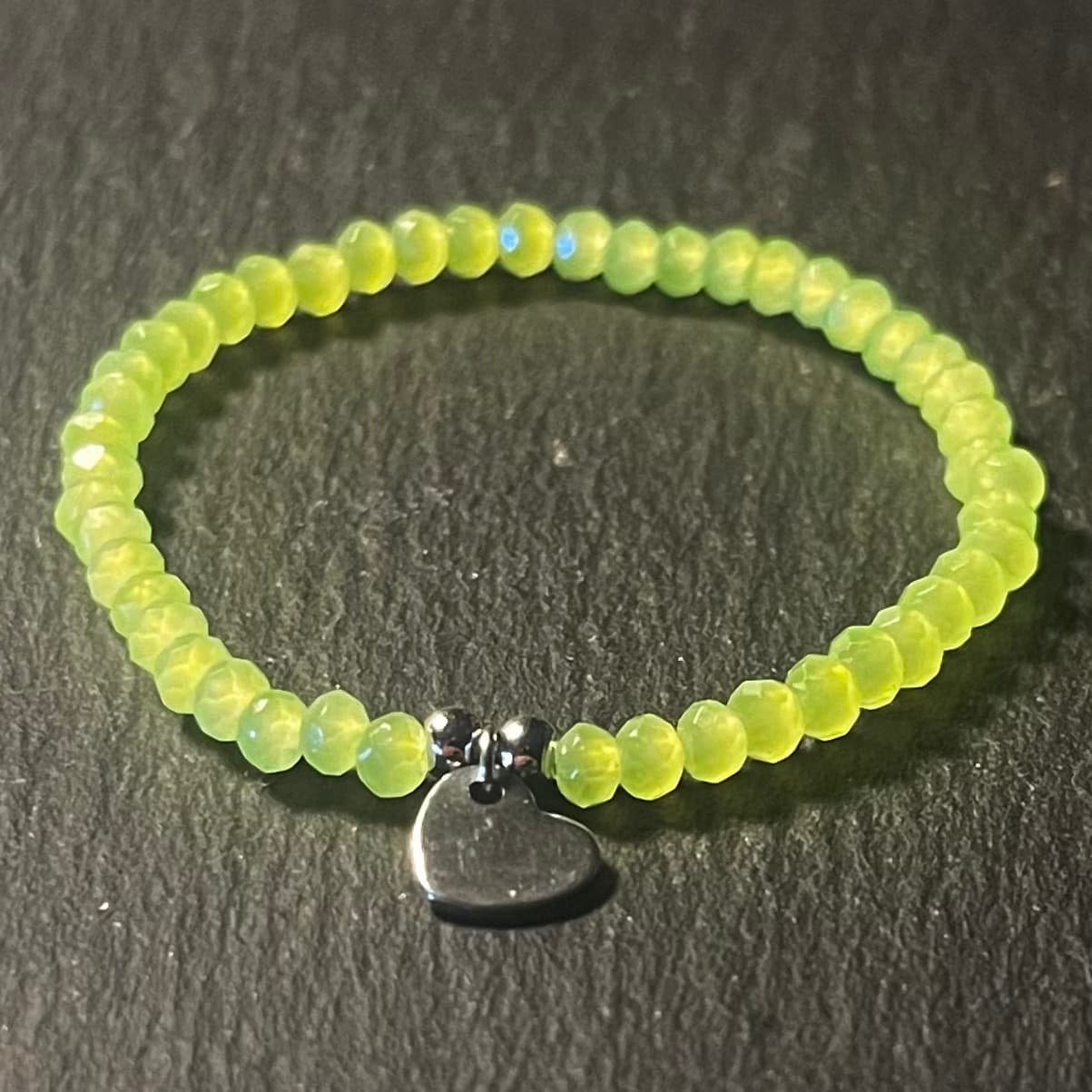 Bracelet enfant en perles à facettes aux couleurs acidulées et d'un pendentif cœur en acier inoxydable argenté ou doré conçu sur mesure avec des perles