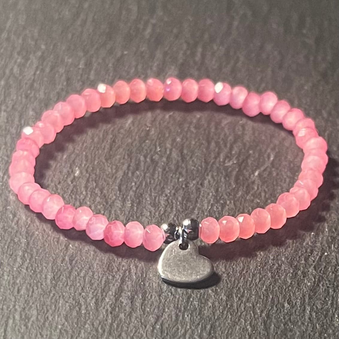 Bracelet enfant en perles à facettes aux couleurs acidulées et d'un pendentif cœur en acier inoxydable argenté ou doré conçu sur mesure avec des perles