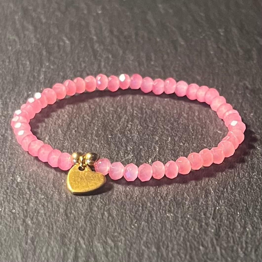 Bracelet enfant en perles à facettes aux couleurs acidulées et d'un pendentif cœur en acier inoxydable argenté ou doré conçu sur mesure avec des perles