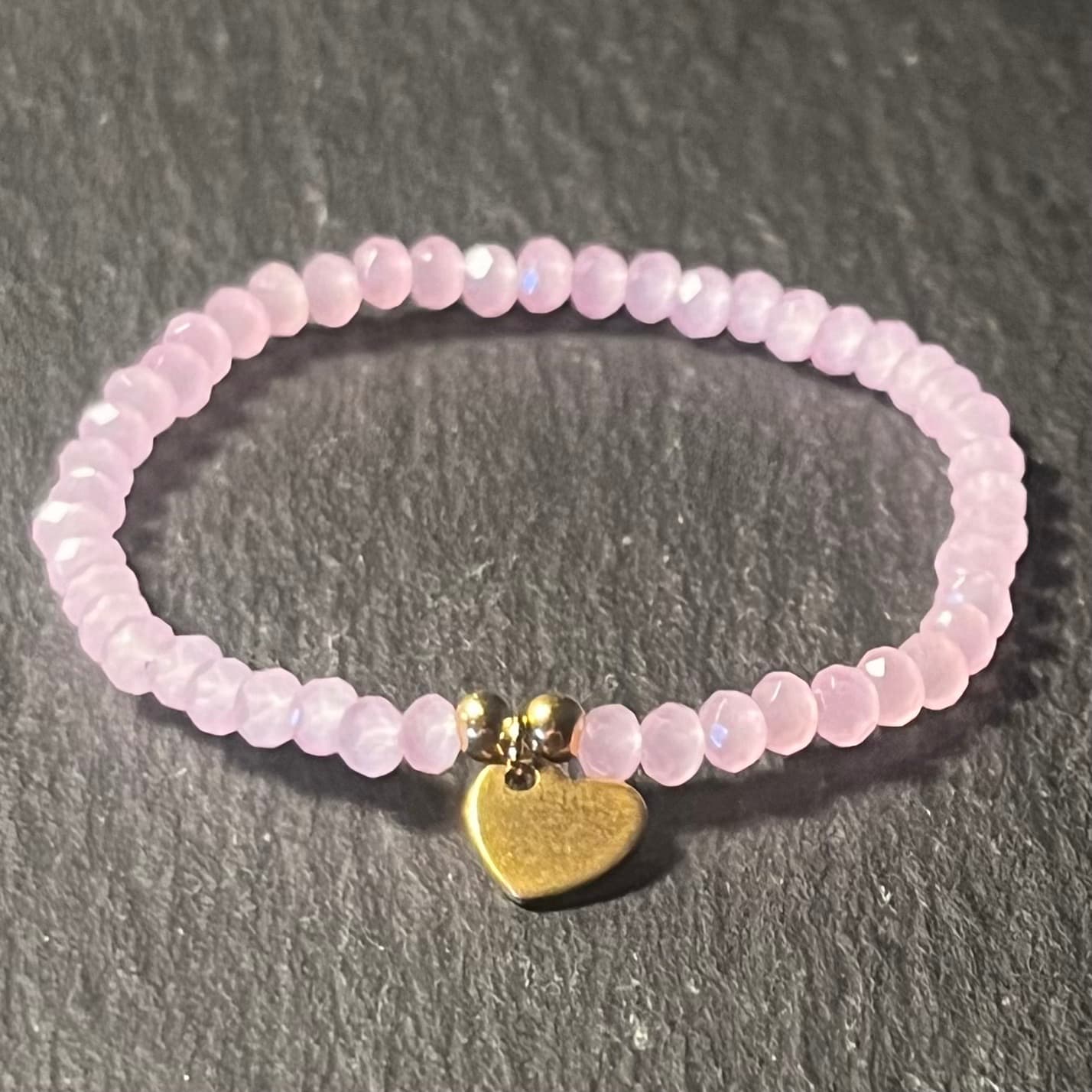 Bracelet enfant en perles à facettes aux couleurs acidulées et d'un pendentif cœur en acier inoxydable argenté ou doré conçu sur mesure avec des perles